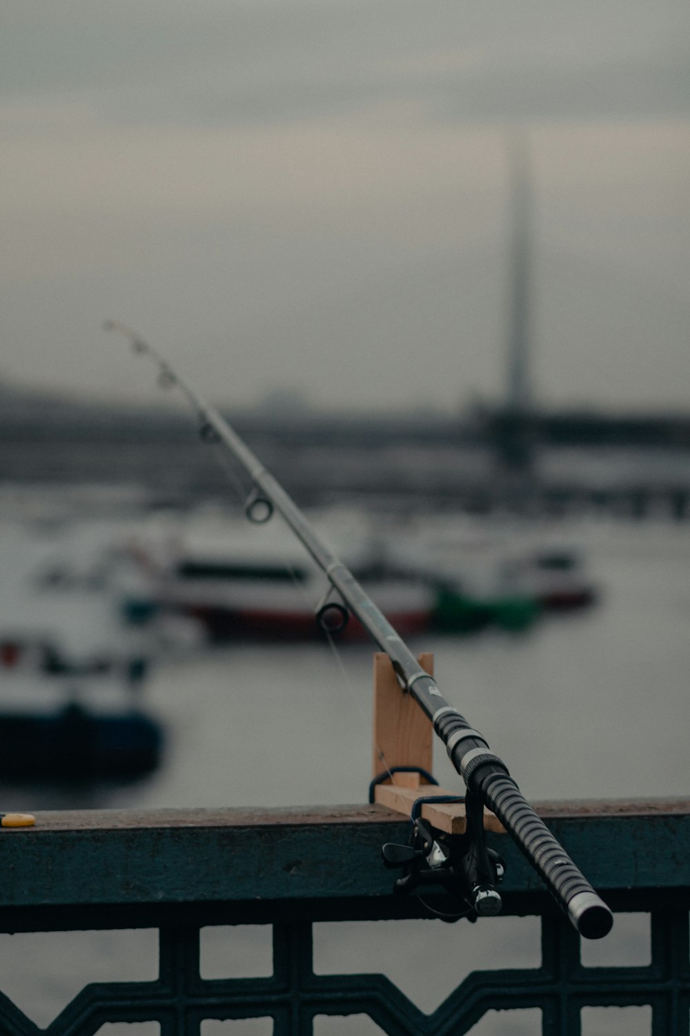 canna da pesca bianca su ringhiere in legno marrone