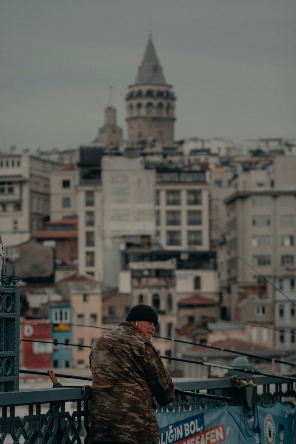 man in brown jacket standing on top of building during daytime