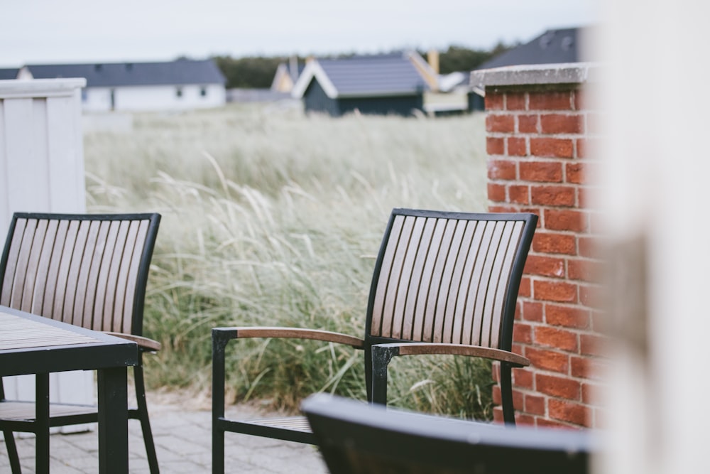 black wooden armchair beside brown brick wall