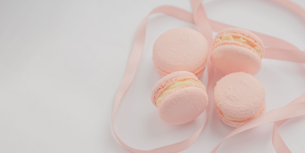 pink and white macaroons on white surface