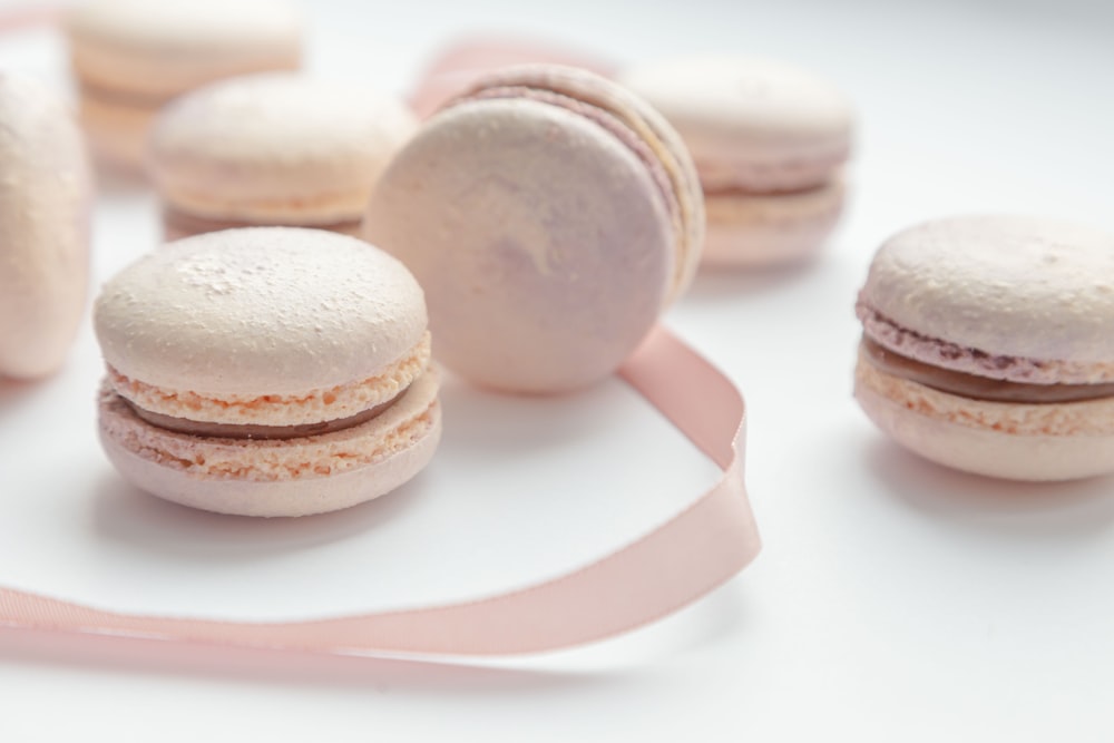 macarons brancos e marrons sobre placa cerâmica branca