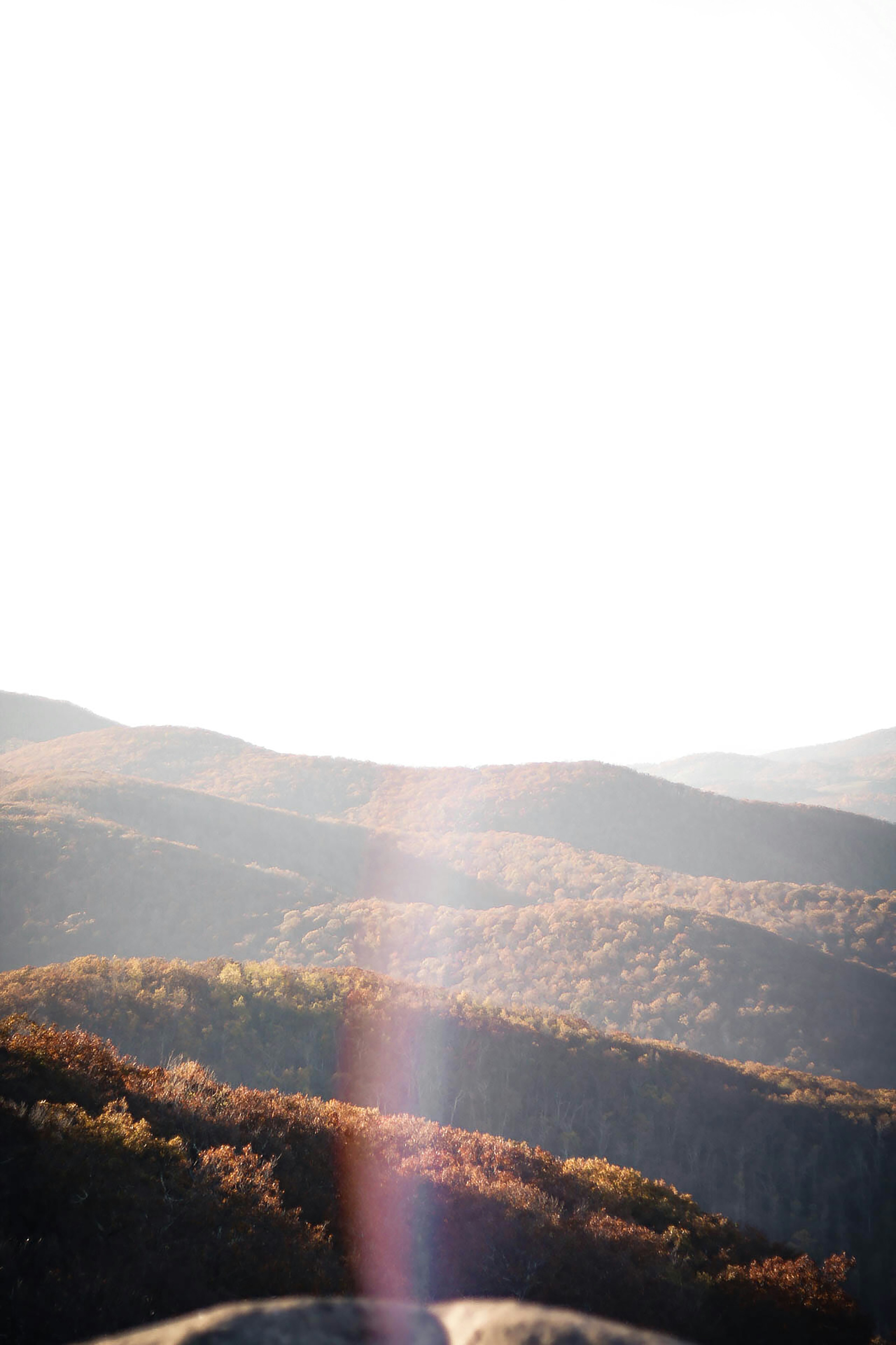 brown and green mountains under white sky during daytime