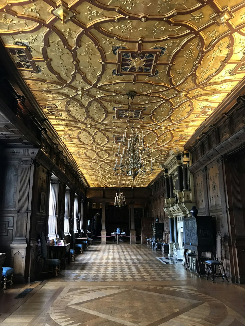 people walking on hallway with gold and white ceiling
