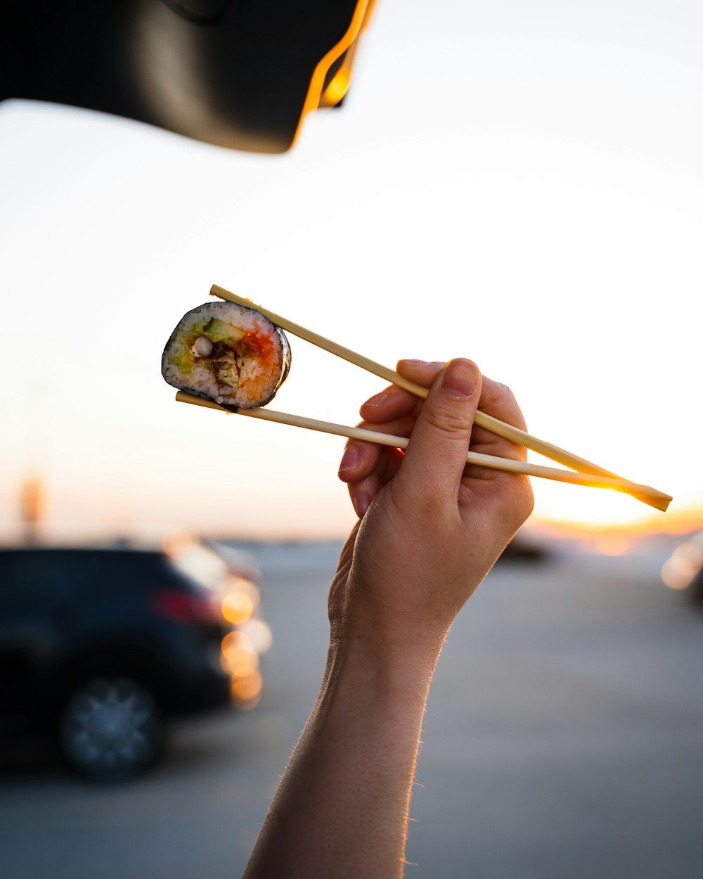 person holding brown wooden chopsticks