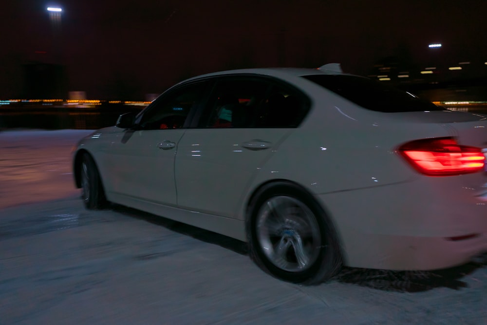 white sedan on gray asphalt road during night time