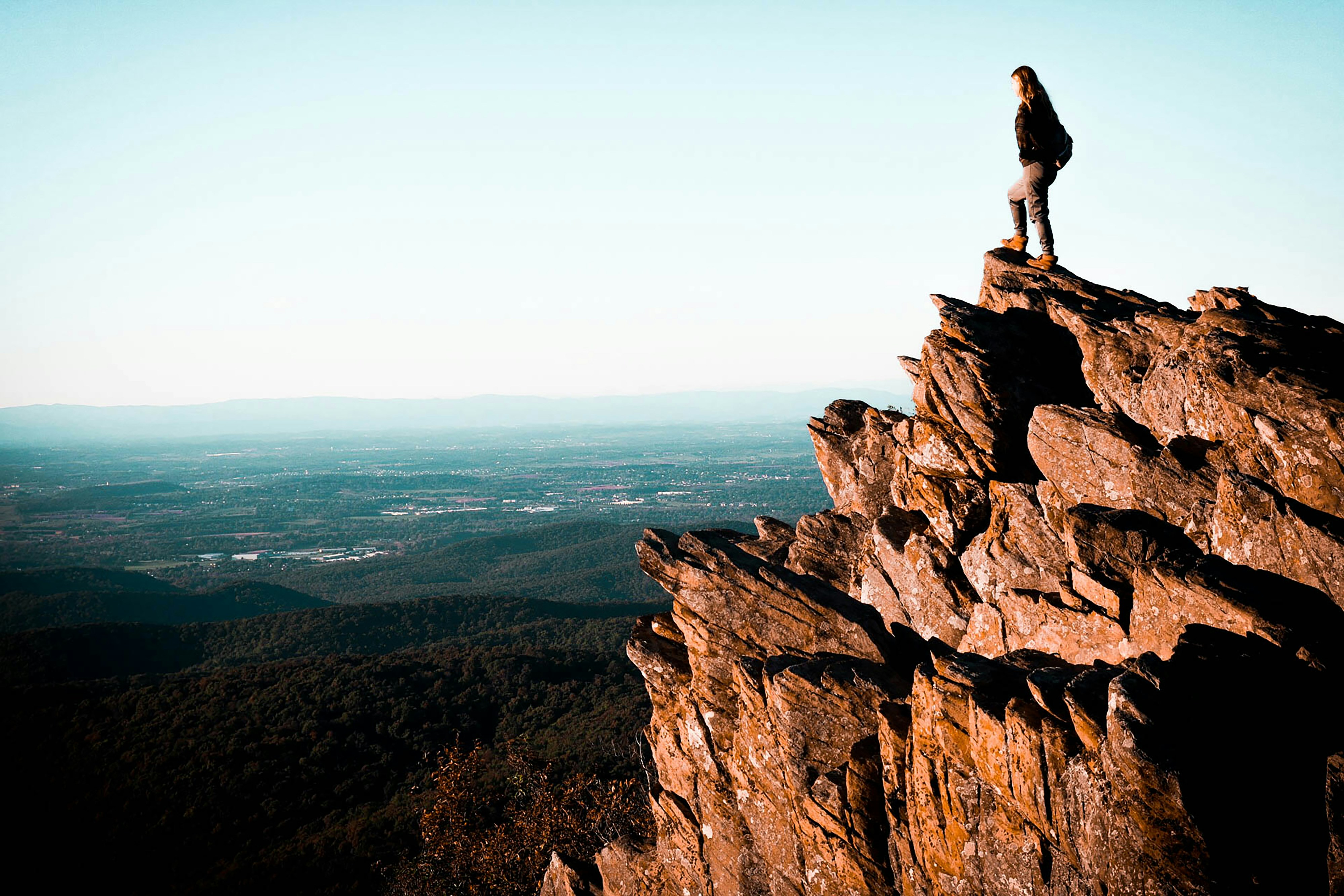 person sitting on brown rock formation during daytime