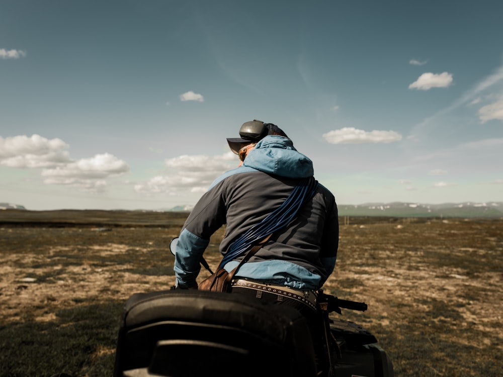 man in blue jacket and black pants sitting on black motorcycle