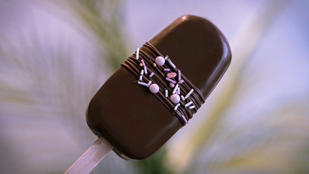 brown and white lollipop with white and purple beads