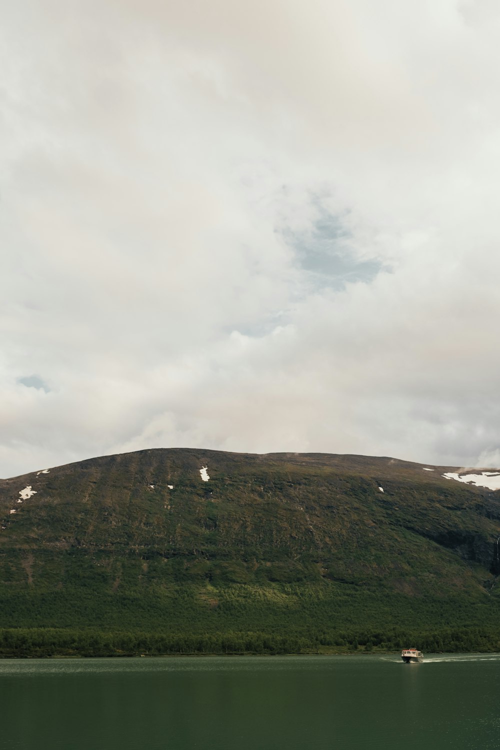 green grass covered mountain under cloudy sky during daytime