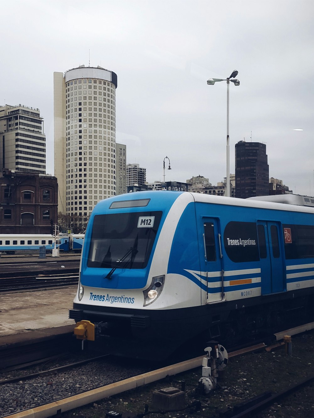 Tren blanco y azul en la vía férrea durante el día