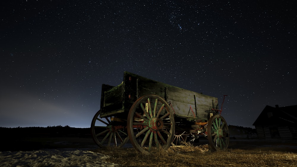 black wooden carriage on brown sand during night time