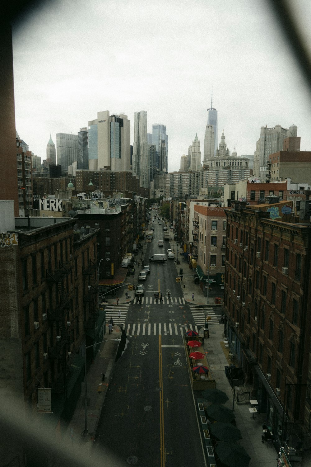 cars on road between high rise buildings during daytime