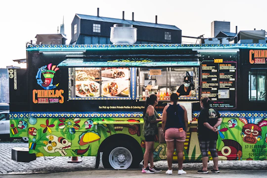 a group of people standing in front of a food truck