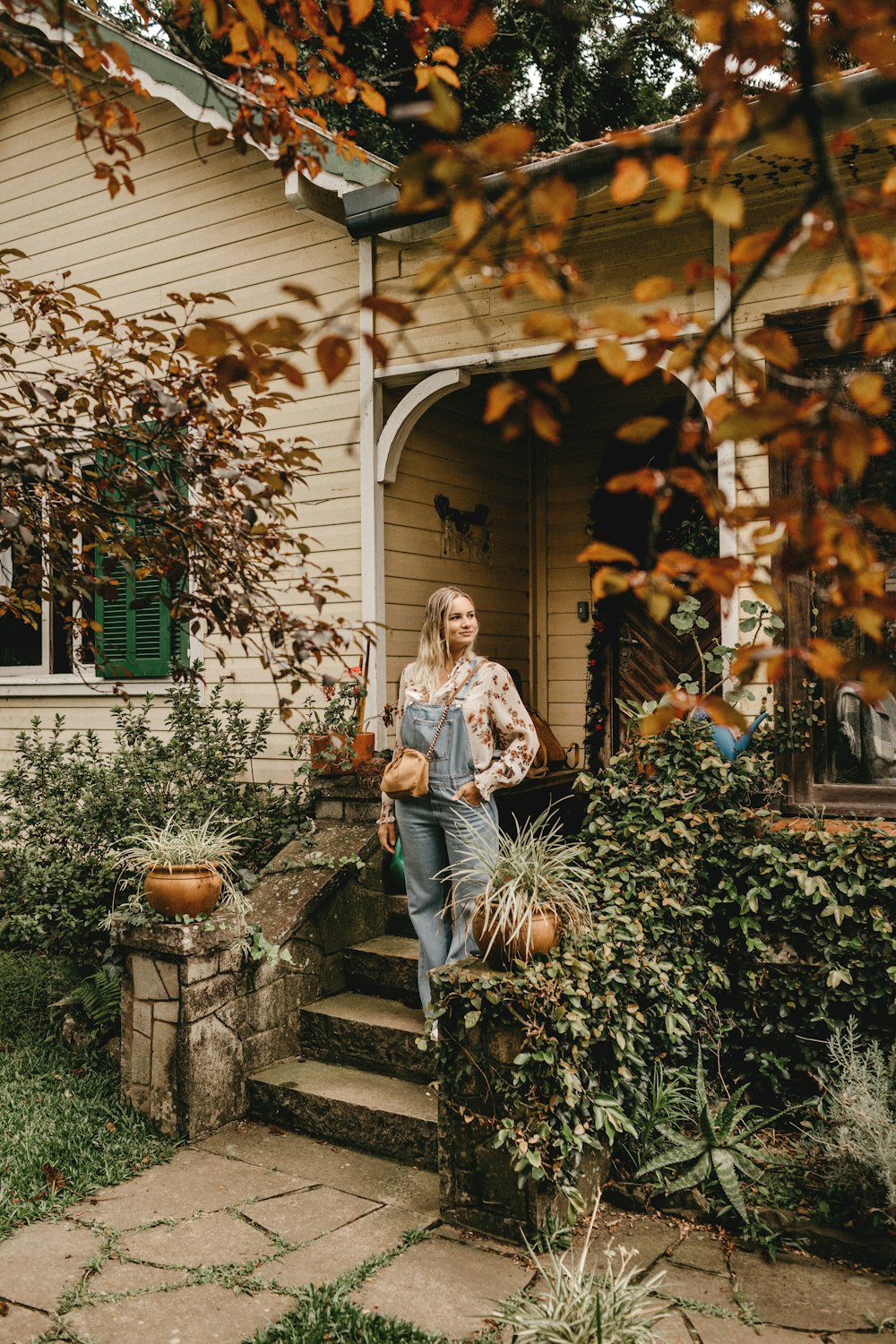 woman in white long sleeve shirt and blue denim jeans sitting on gray concrete bench