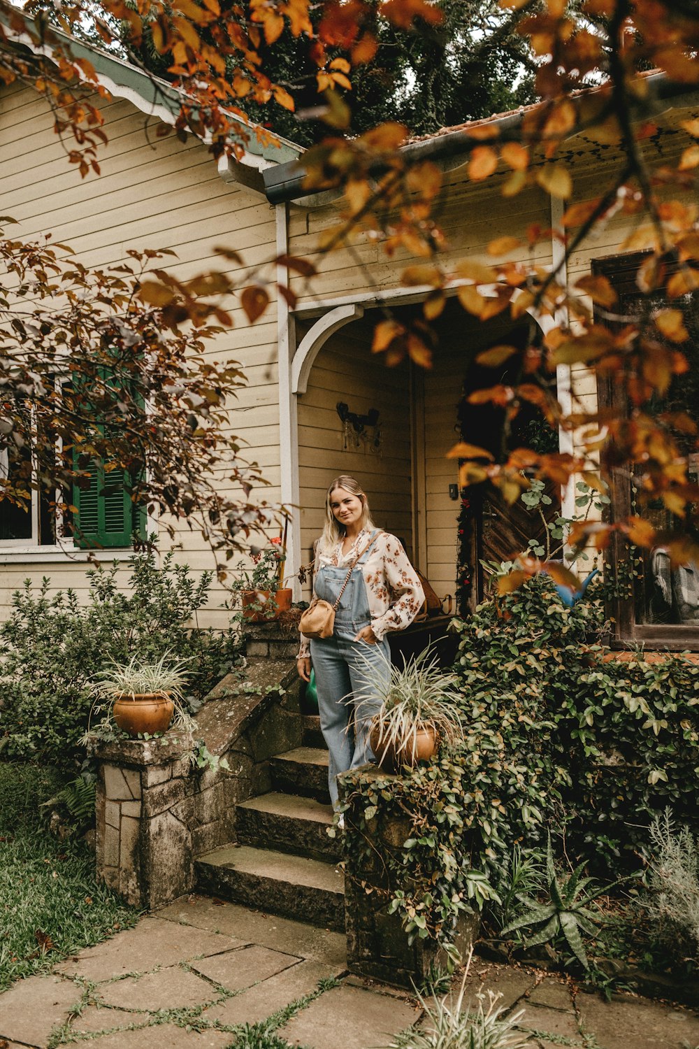 woman in white long sleeve shirt and blue denim jeans sitting on gray concrete bench