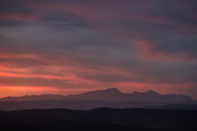 A close-up of a detailed landscape painting capturing a serene sunset over mountains.