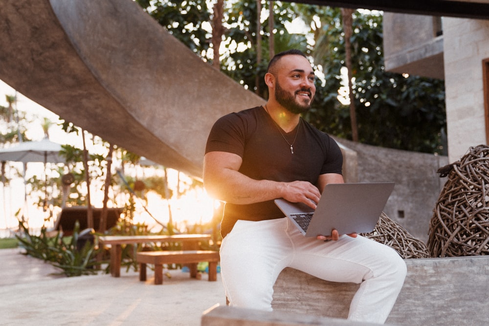 man in brown crew neck t-shirt and white pants sitting on brown wooden bench during