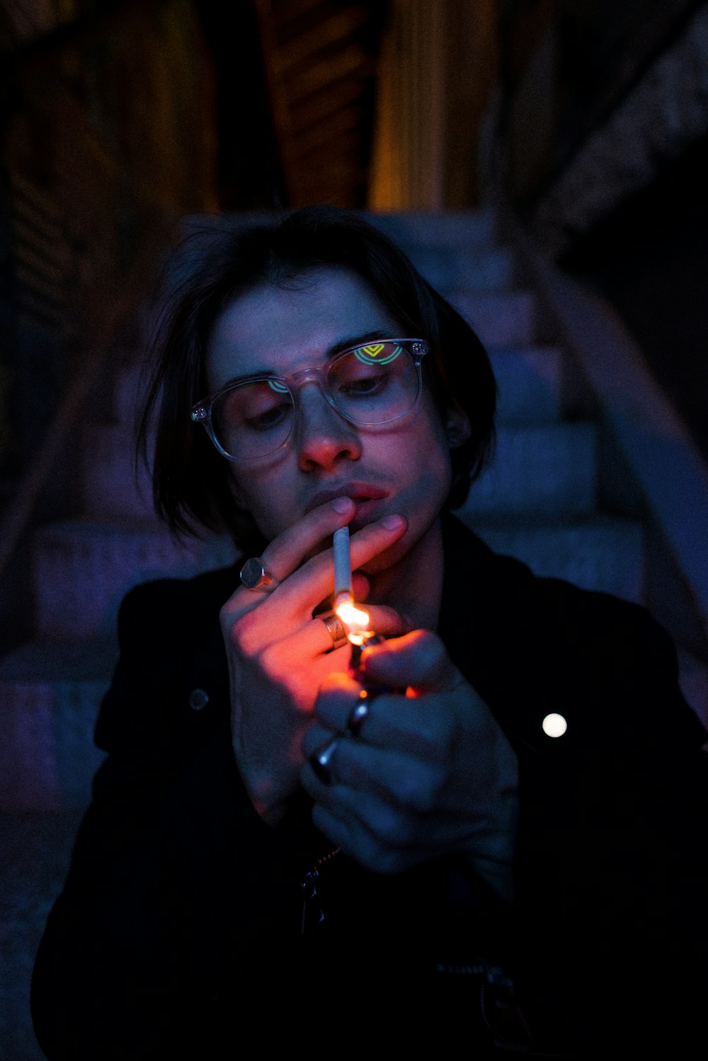 mujer con gafas de montura negra fumando