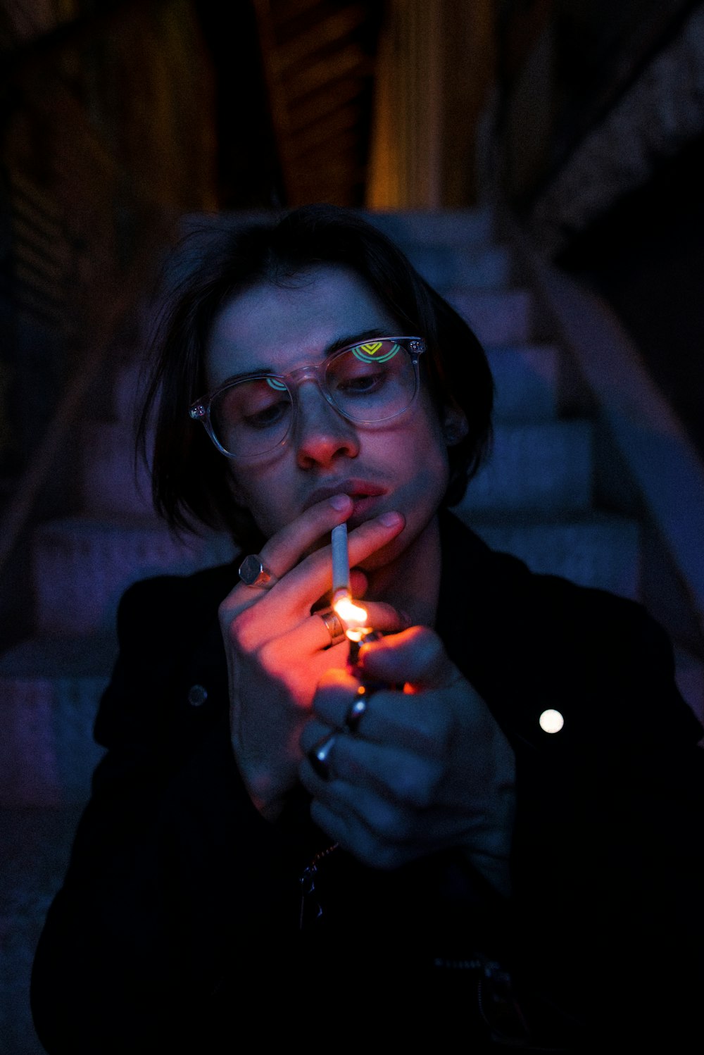 woman in black framed eyeglasses smoking