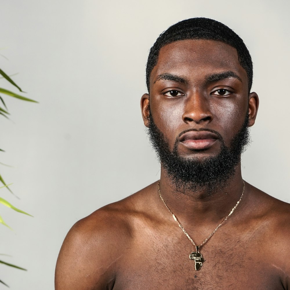 topless man wearing silver necklace