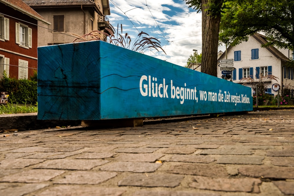 a large blue box sitting on the side of a road