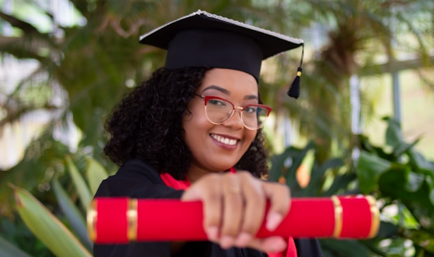 smiling woman wearing academic dress and black academic hat