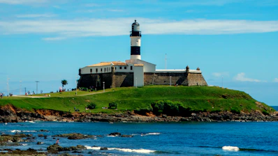 white and black lighthouse near body of water during daytime