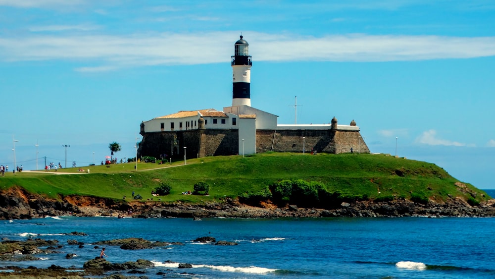 white and black lighthouse near body of water during daytime