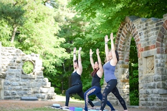 3 women doing yoga in an outdoor setting