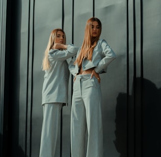 2 women in white long sleeve shirt standing beside glass window