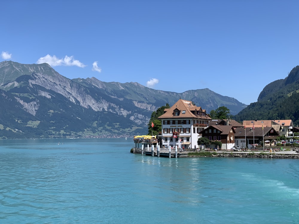 houses near body of water and mountain range