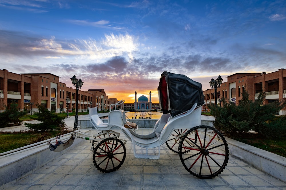 white wooden carriage on gray concrete pavement during daytime