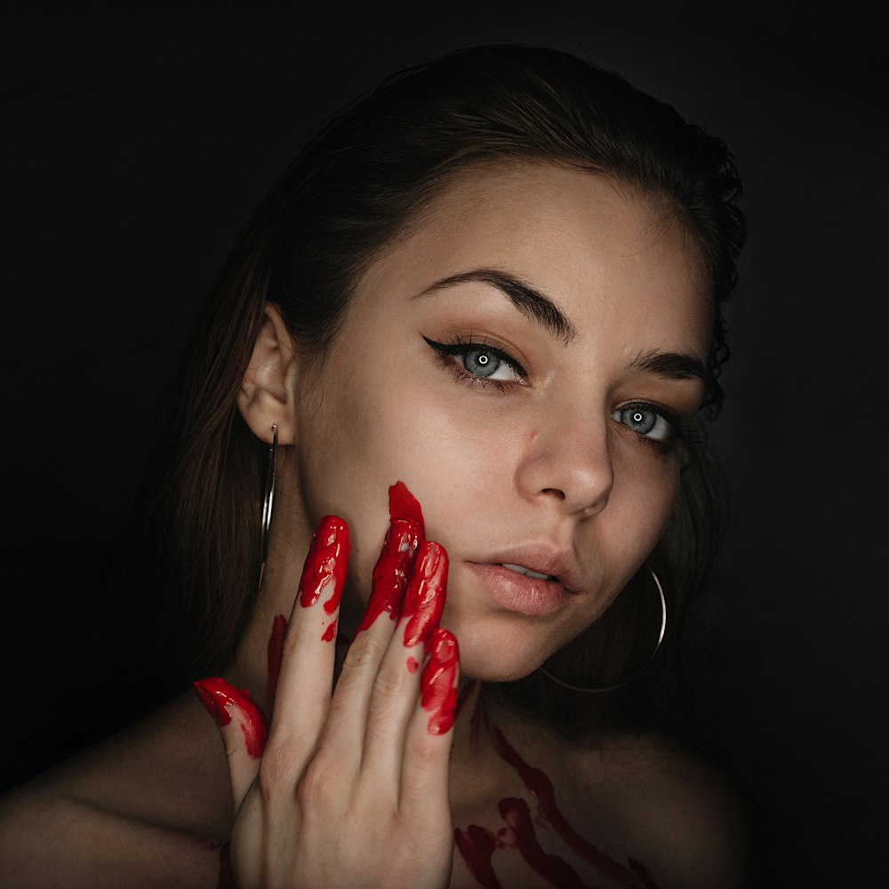 woman with red lipstick holding red petals