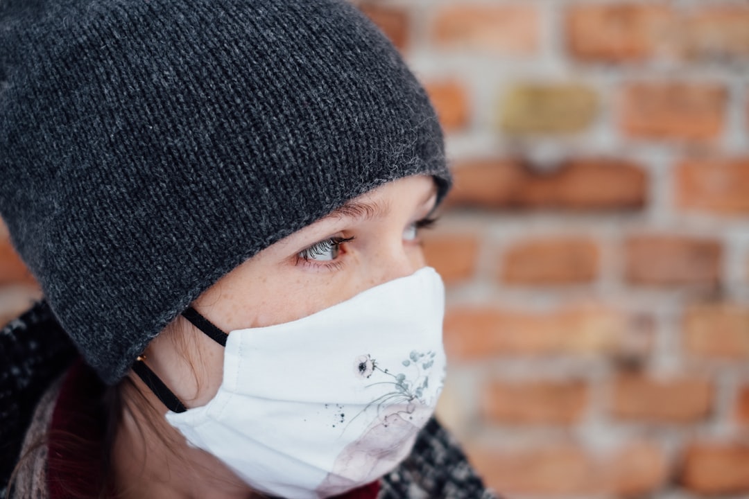 person in black knit cap and white face mask