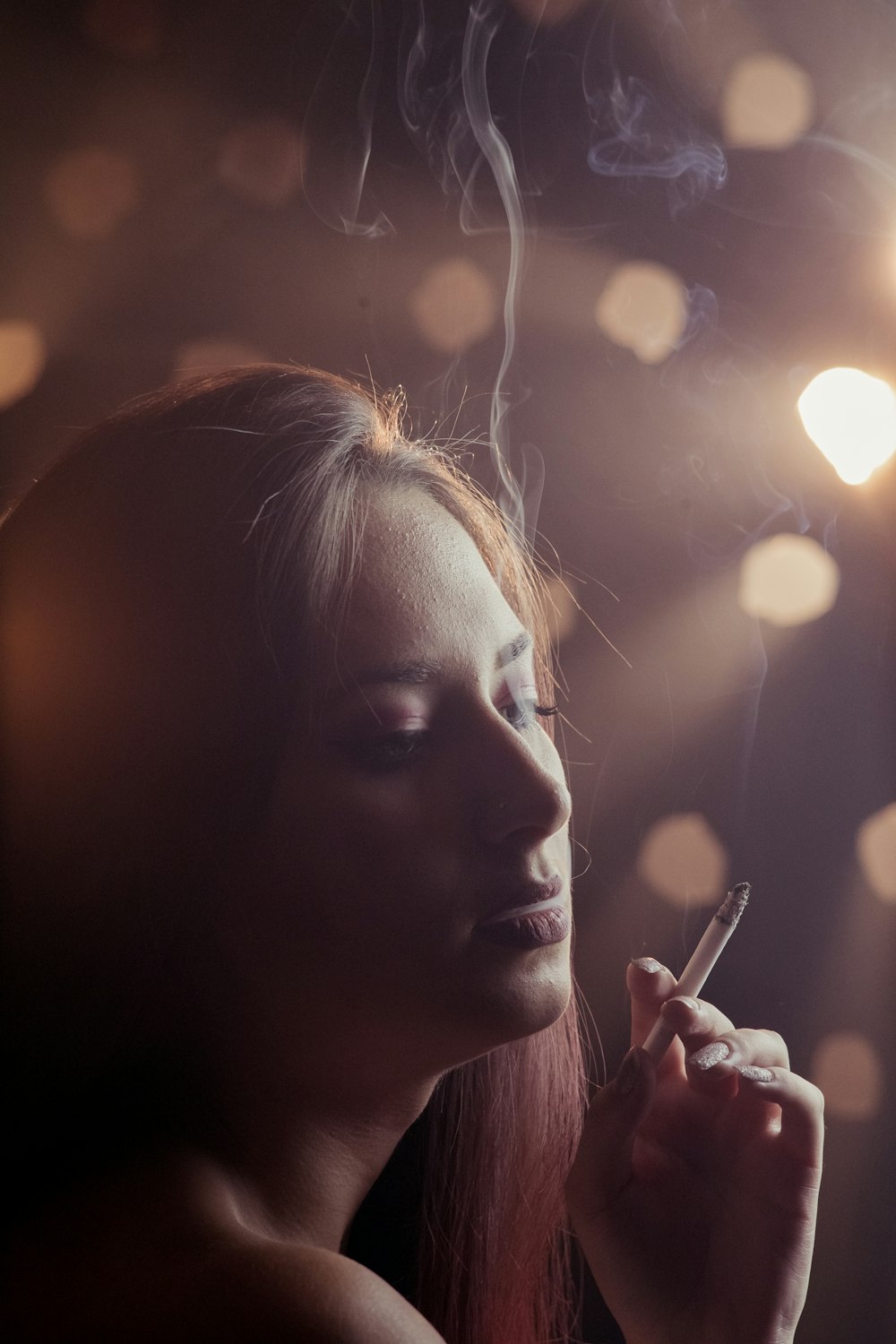 woman holding cigarette stick in front of her face