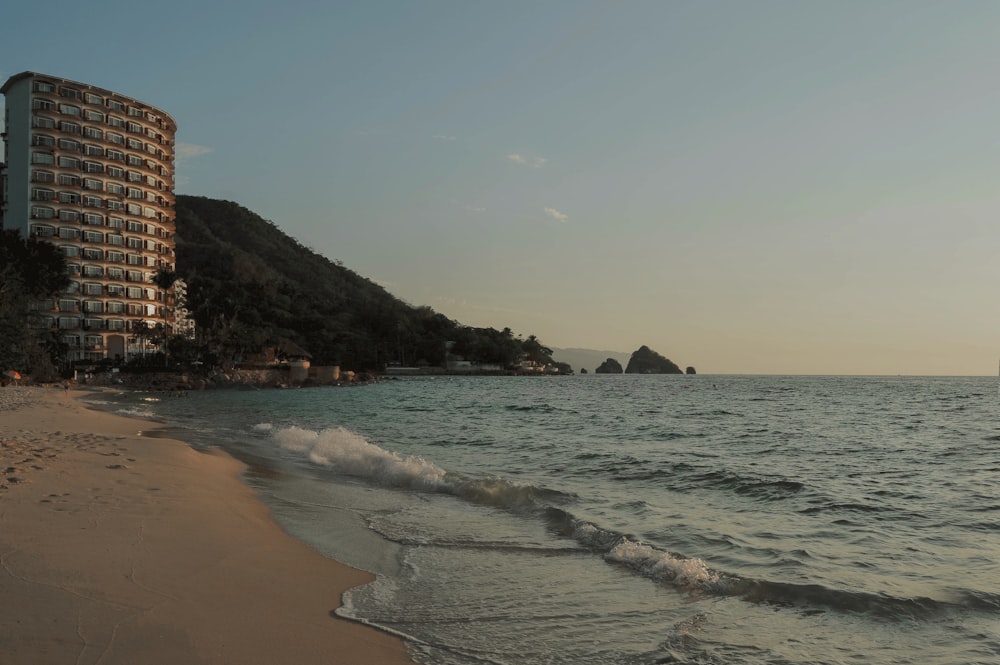 Plage de sable brun avec les vagues de l’océan s’écrasant sur le rivage pendant la journée