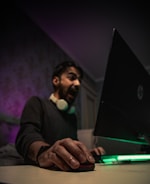 man in black long sleeve shirt holding black laptop computer