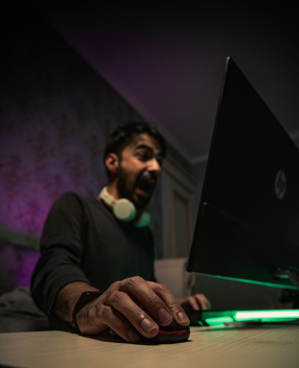 man in black long sleeve shirt holding black laptop computer