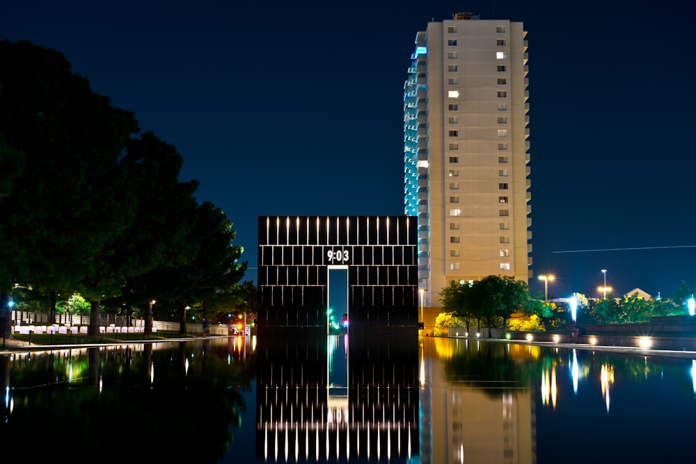Immeuble de grande hauteur près d’un plan d’eau pendant la nuit