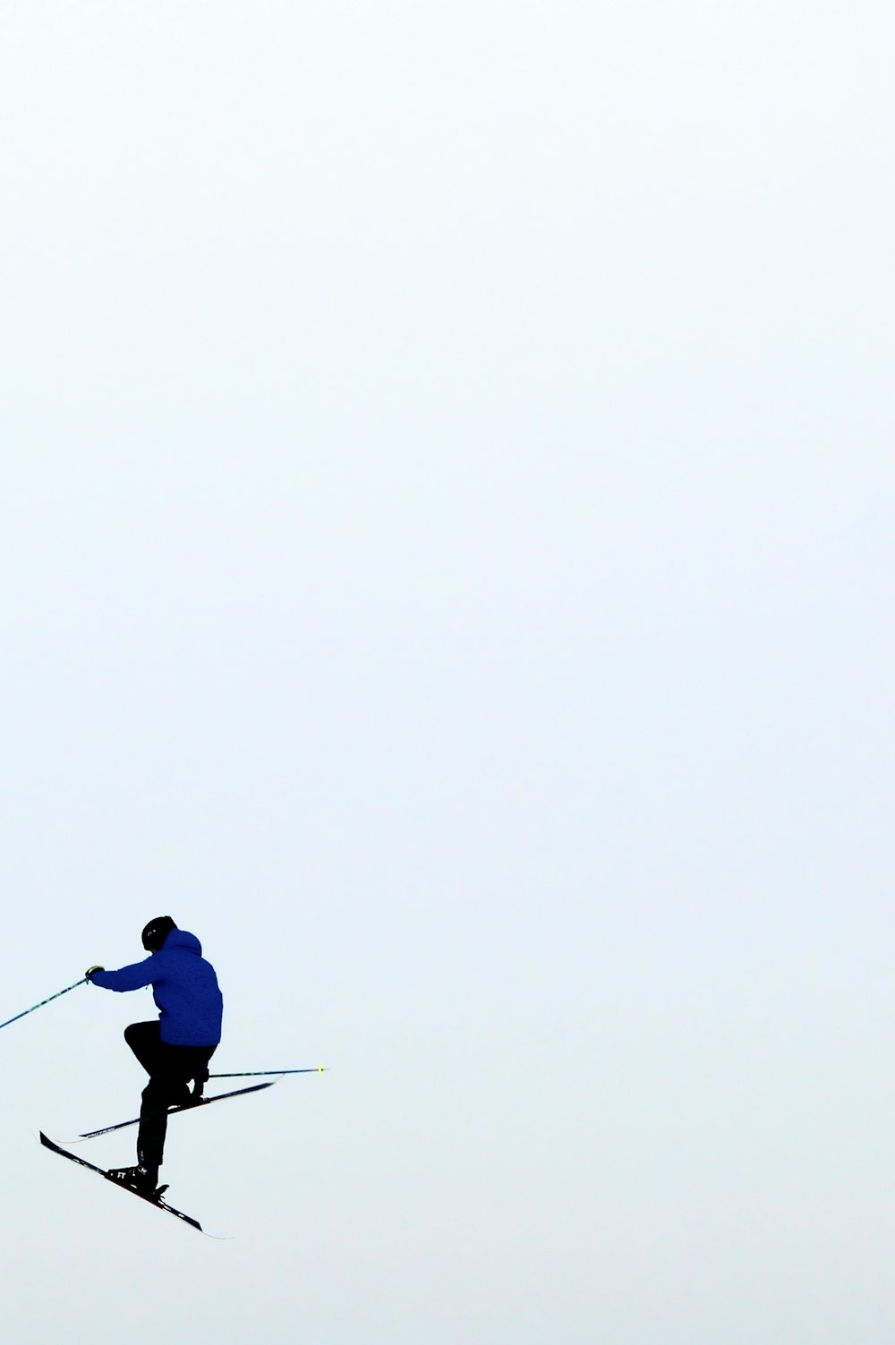 man in blue jacket and black pants holding stick