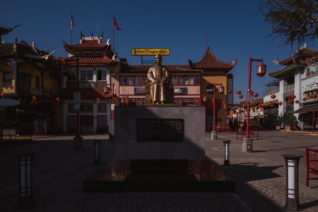 gold statue in front of red and white building