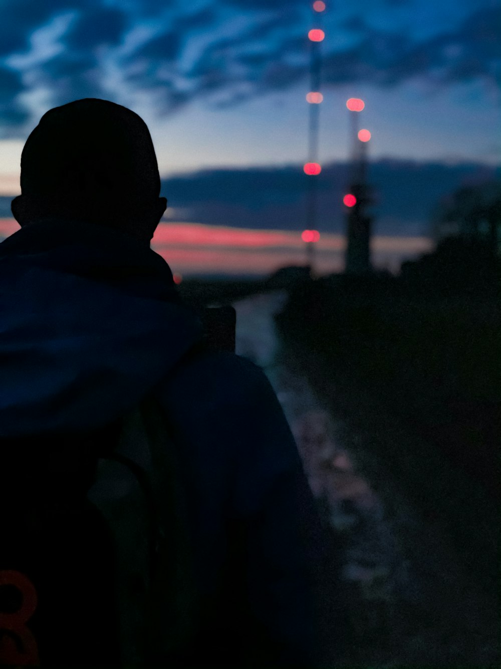 man in black hoodie standing on road during night time