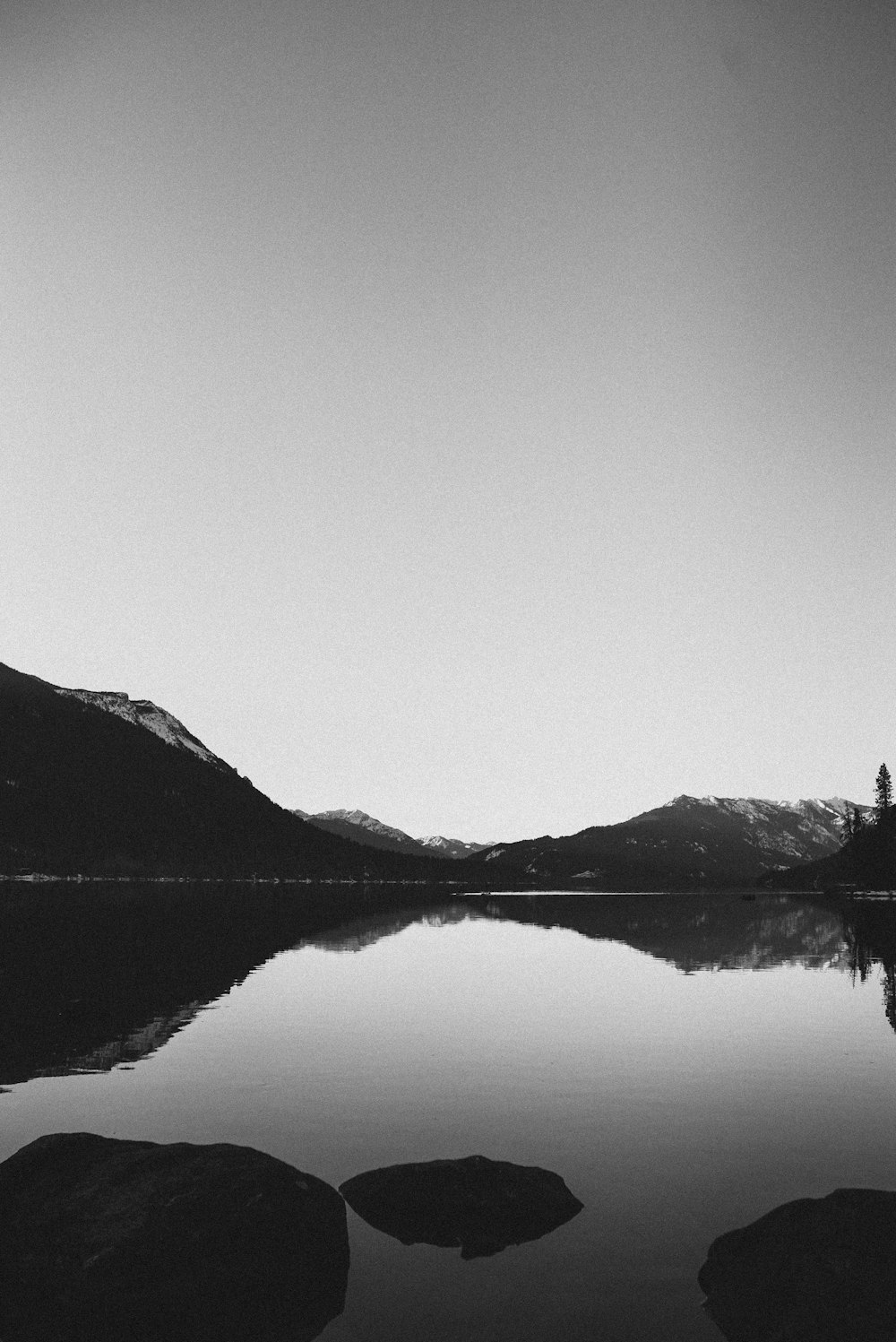 body of water near mountain during daytime