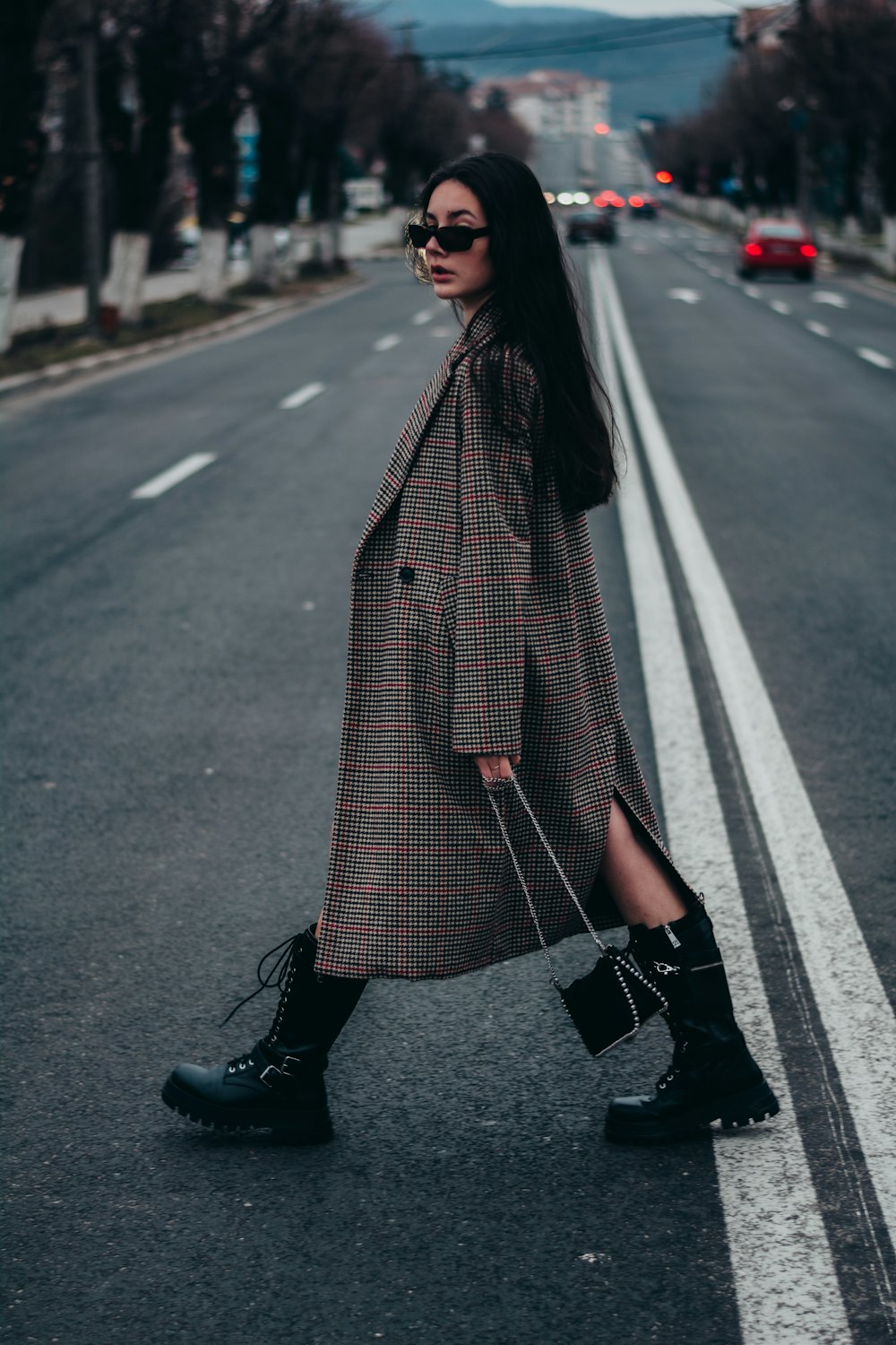 woman in black coat standing on the road