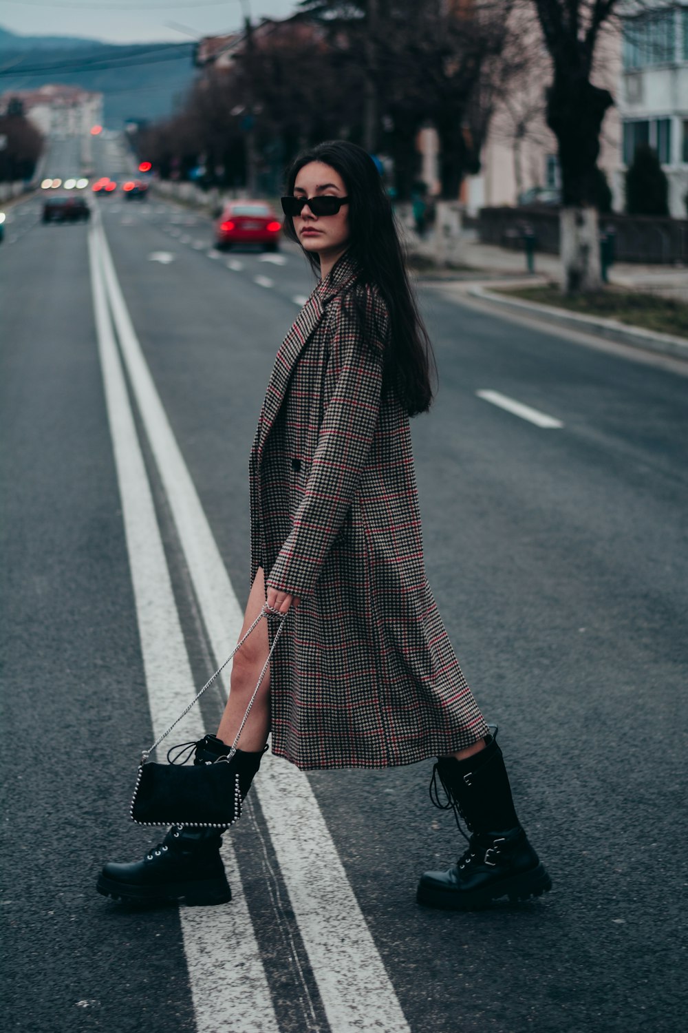 woman in black and white scarf standing on the road