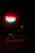 A neon sign glows brightly in the dark, featuring the words 'Bel-Vista Healthcare Center 5001'. The sign is illuminated with red and blue light, casting its glow on the surrounding area. In the background, a tree and a streetlight are visible, creating a moody atmosphere.