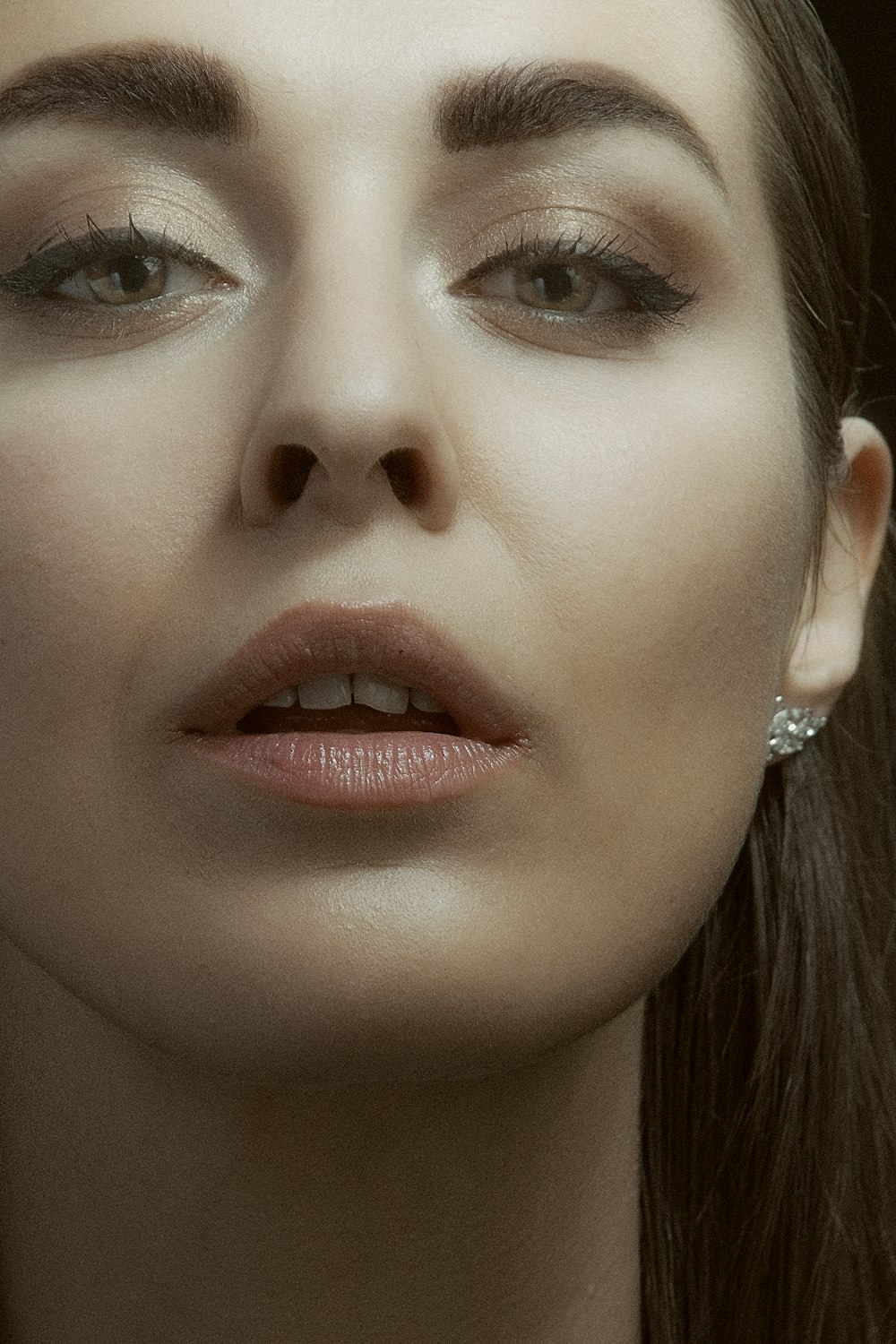 woman with silver and diamond stud earrings
