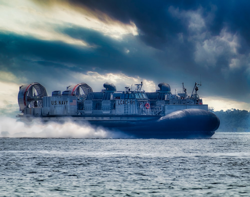 blue and white ship on sea under cloudy sky during daytime