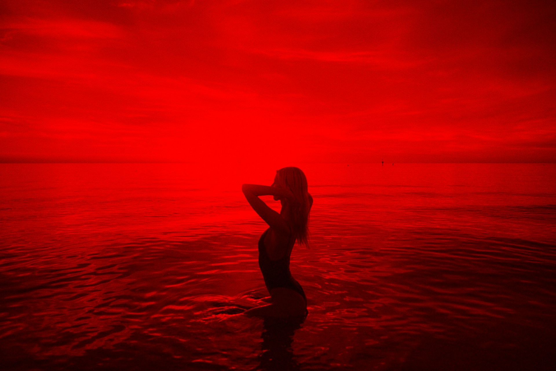 woman in black bikini walking on beach during sunset