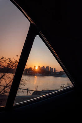 Sunset view through the window of a Nissan Urban vehicle on a coastal road